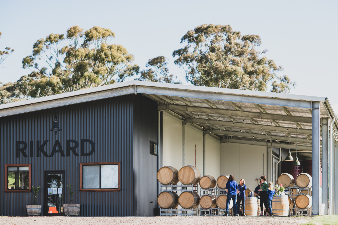 Image of Richard winery with staff standing in front of barrels